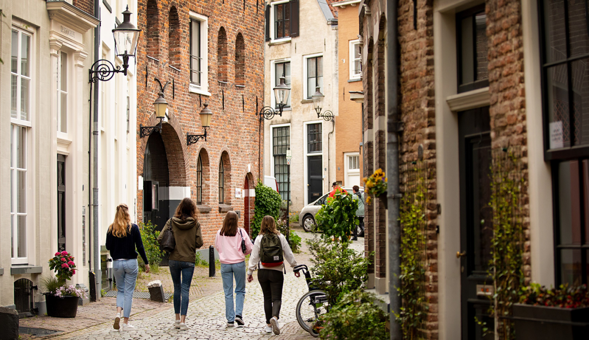 Vier mensen lopen door een straatje in het Bergkwartier in Deventer.
