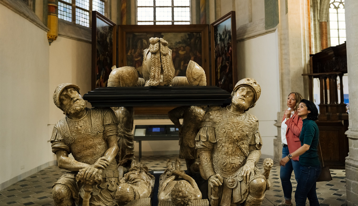 Bezoekers bekijken een grafmonument in de de Grote Kerk in Breda.