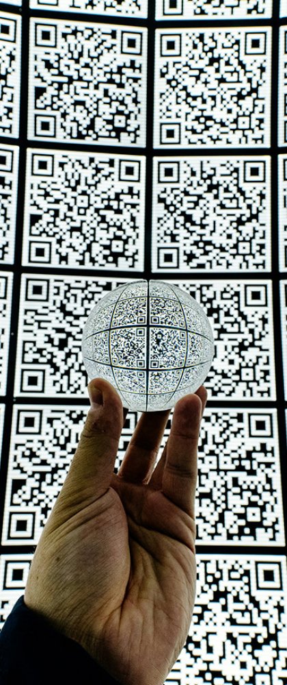 Hand met glazen bal op QR code achtergrond