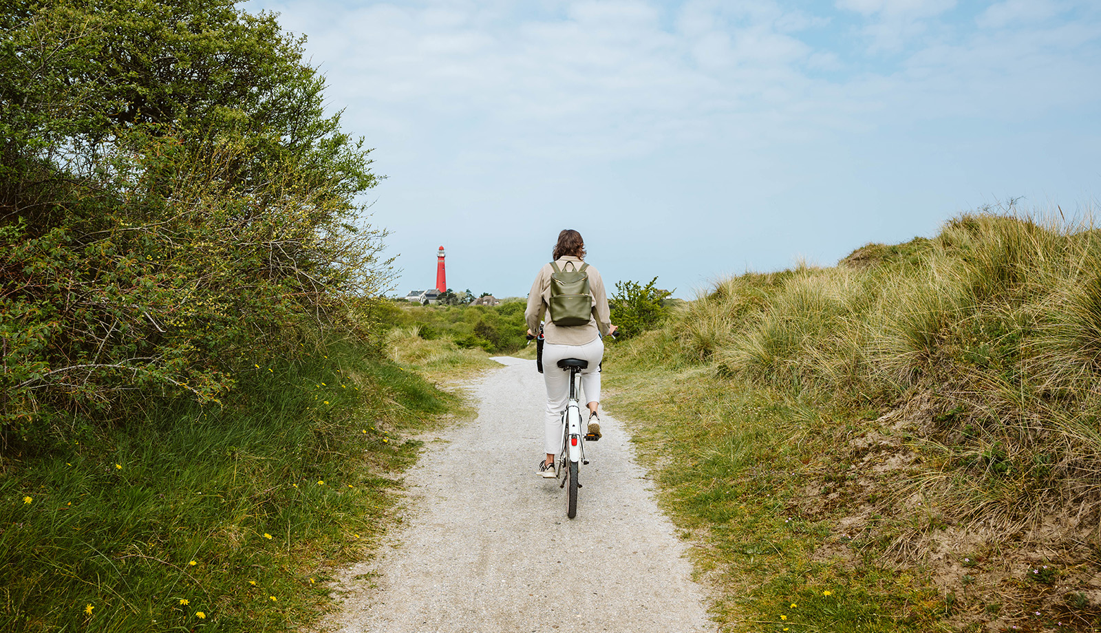 Dame op de fiets op Schiermonnikoog Friesland vuurtoren