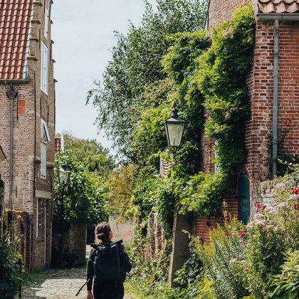 Vrouw wandelt door een groene straat in het Zeeuwse stadje Veere