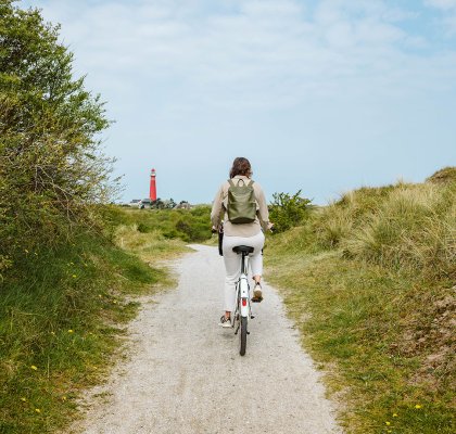 Dame op de fiets op Schiermonnikoog Friesland vuurtoren