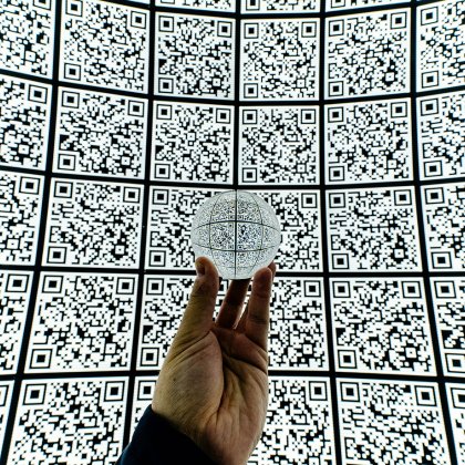 Hand met glazen bal op QR code achtergrond