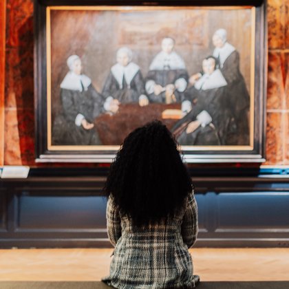 Teylers Museum dame zit op bankje en bekijkt schilderij