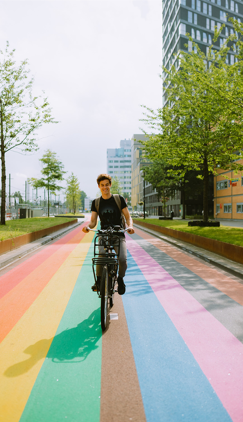Man fietst over regenboogfietspad in Utrecht
