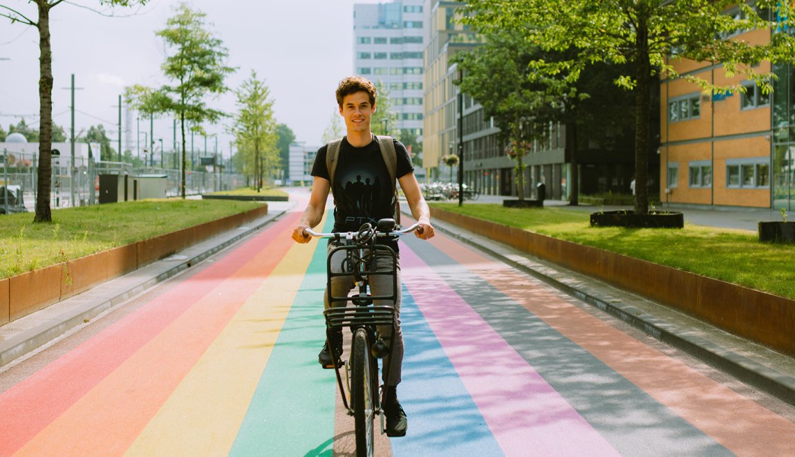 Man fietst over regenboogfietspad in Utrecht