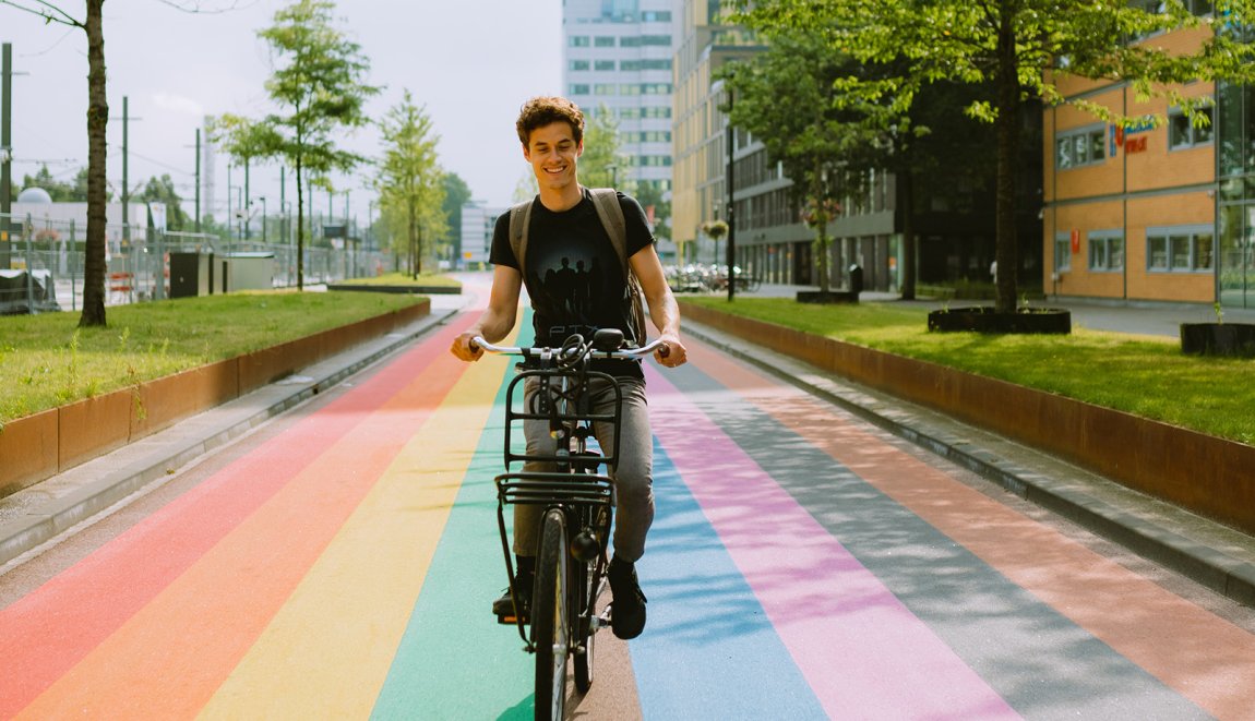 Man fietst over regenboogfietspad in Utrecht Man fietst over regenboogfietspad in Utrecht