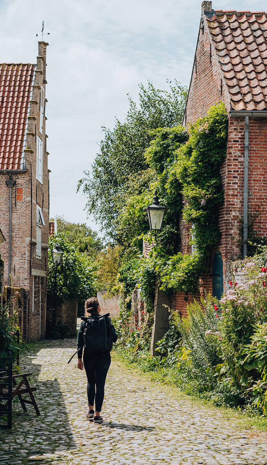 Vrouw wandelt door een groene straat in het Zeeuwse stadje Veere