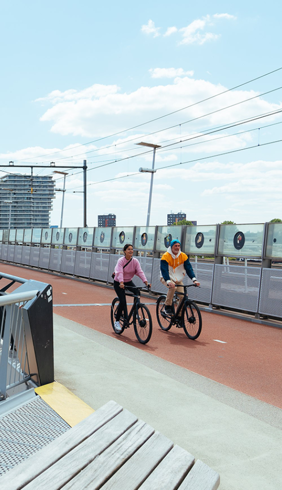 Twee fietsers rijden over een brug