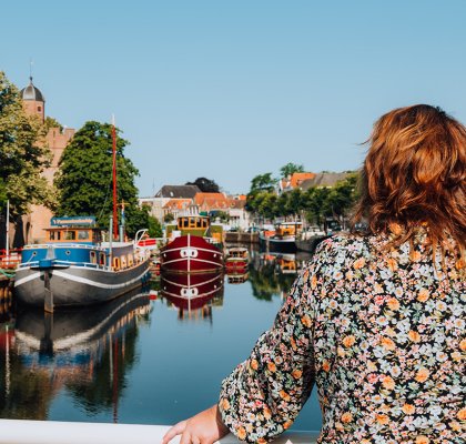 Dame tuurt vanaf brug over een singel in Zwolle