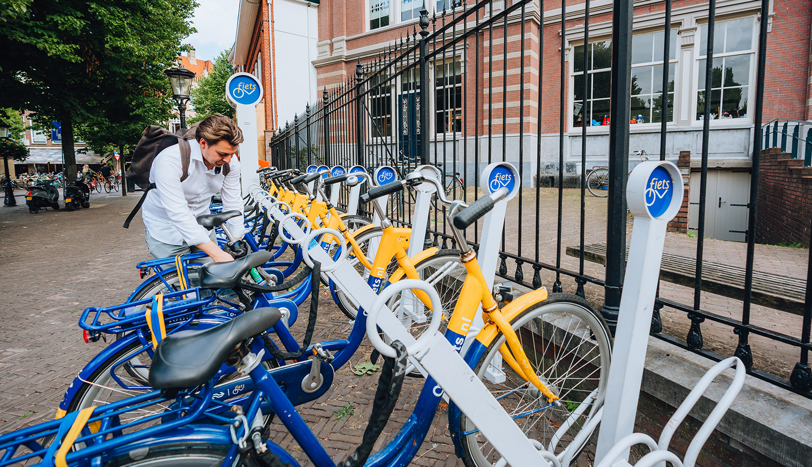 Fietser zet zijn OV fiets op slot op in speciale OV-fietsstalling Fietser zet zijn OV fiets op slot op in speciale OV-fietsstalling