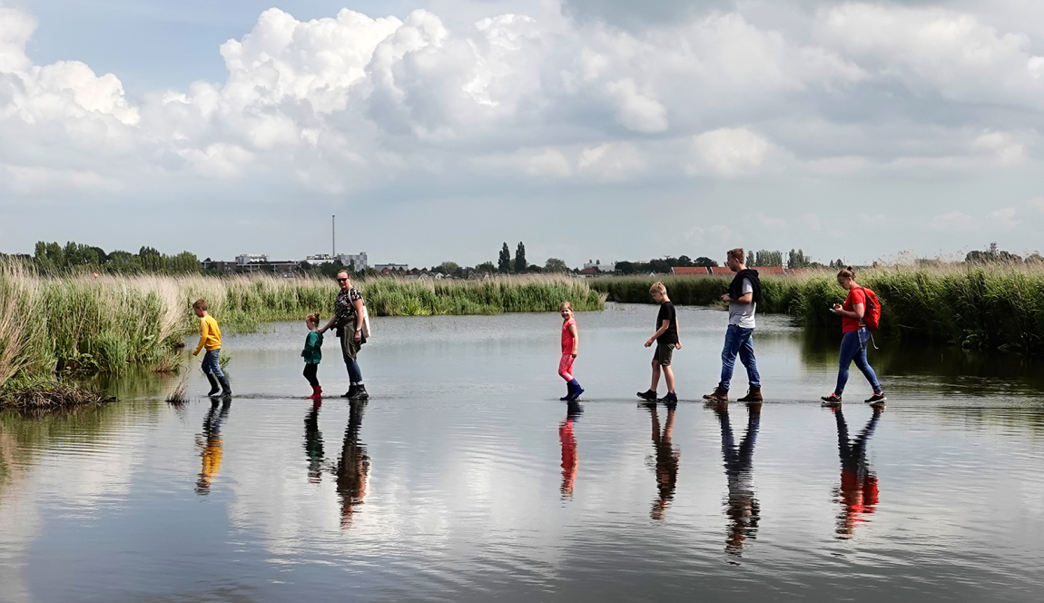 Meerdere mensen lijken over het water te lopen tijdens het Wandelen over Water-evenement