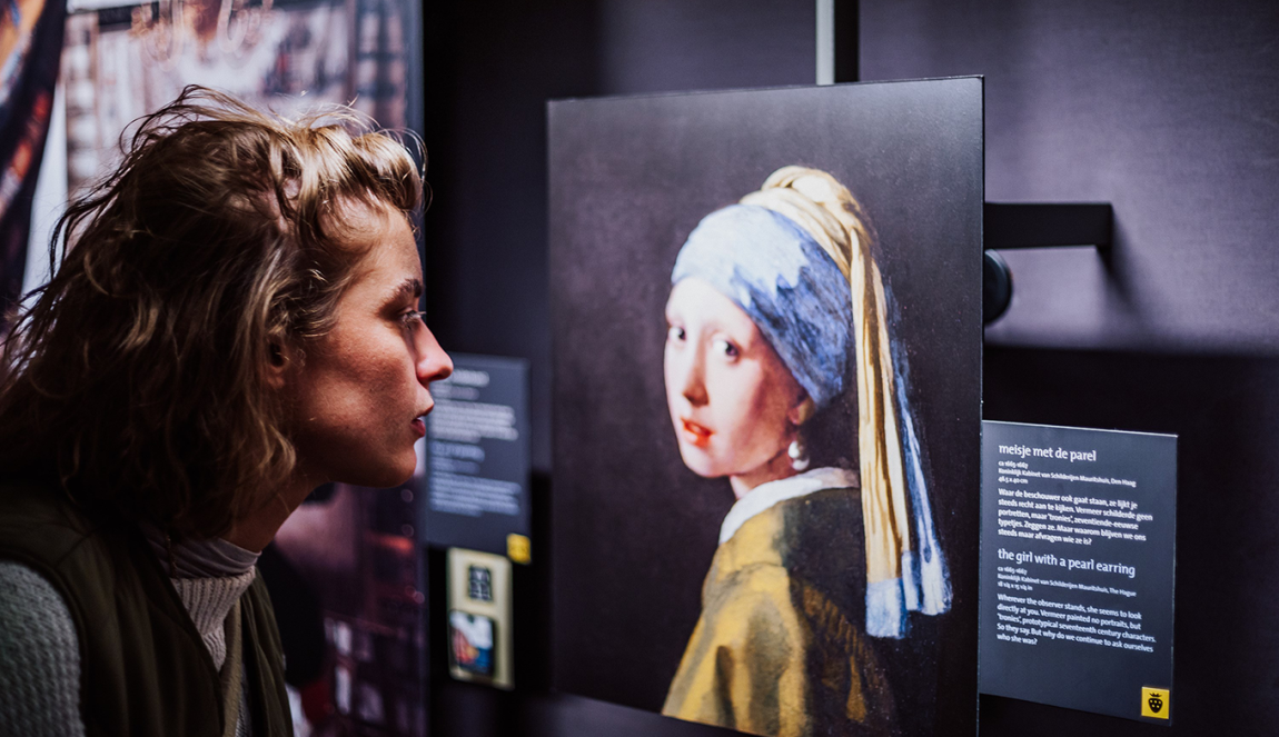 Een bezoeker van het Vermeer Centrum in Delft bekijkt een replica van 'Meisje met de Parel'