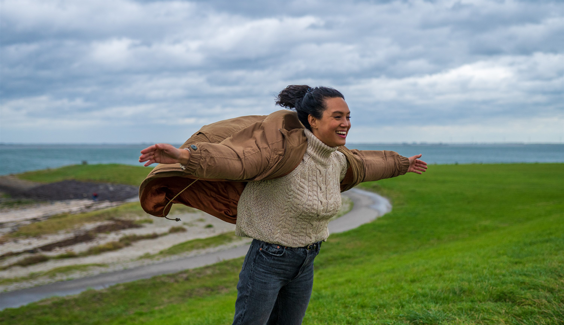 Vrouw leunt tegen de wind