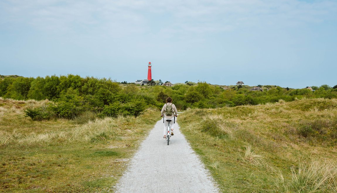 Schiermonnikoog fietster en rode vuurtoren Schiermonnikoog fietster en rode vuurtoren